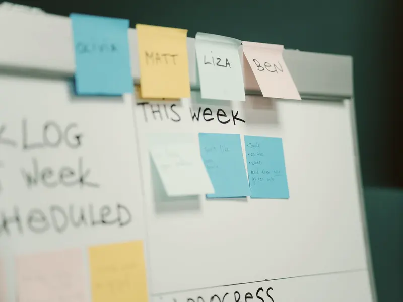 A team's board with Backlog, This Week and In Progress columns, cards claimed by name.